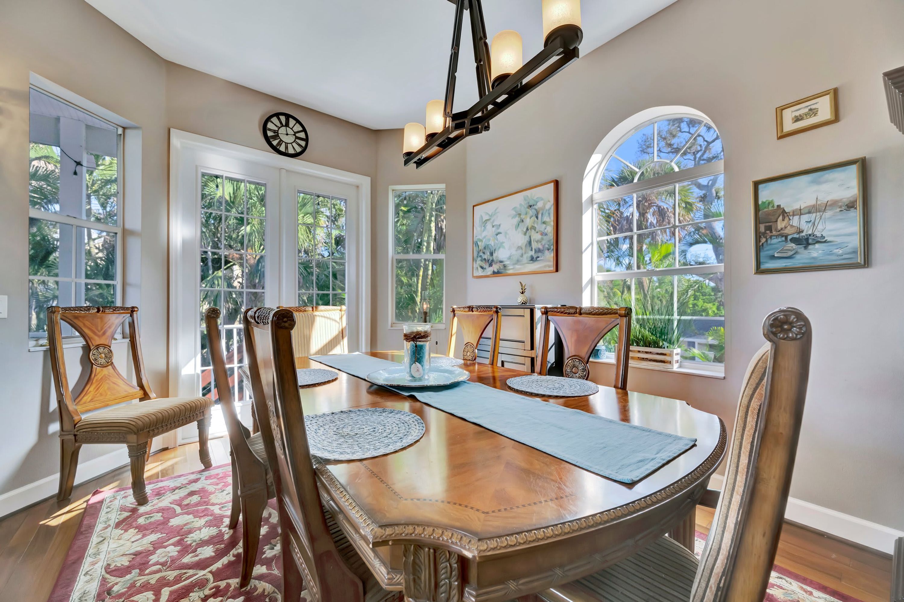A dining area with a wooden table, chairs, and a chandelier.