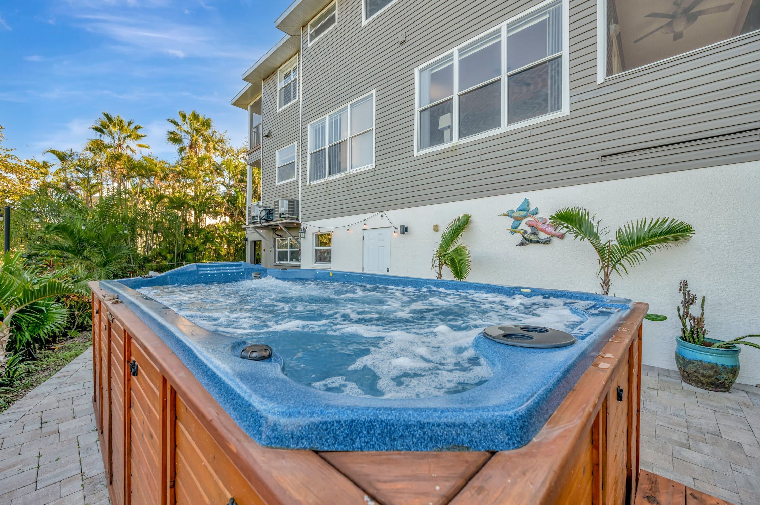 A hot tub in a backyard with a house in the background.