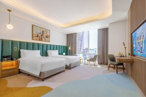 A hotel room with two beds, a desk, a chair, a TV, and a large window. - Edge Riyadh Al Rabie (Riyadh)