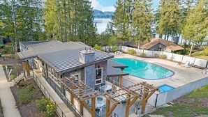 A residential property with a swimming pool, outdoor seating, and a view of a lake. - Aqua Vista Condo at Blue Heron Resort (Union)