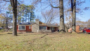 A single-story house with a brick exterior and a stone chimney. - 1 Mi to Graceland: Quiet Home w/ Private Yard (Memphis)