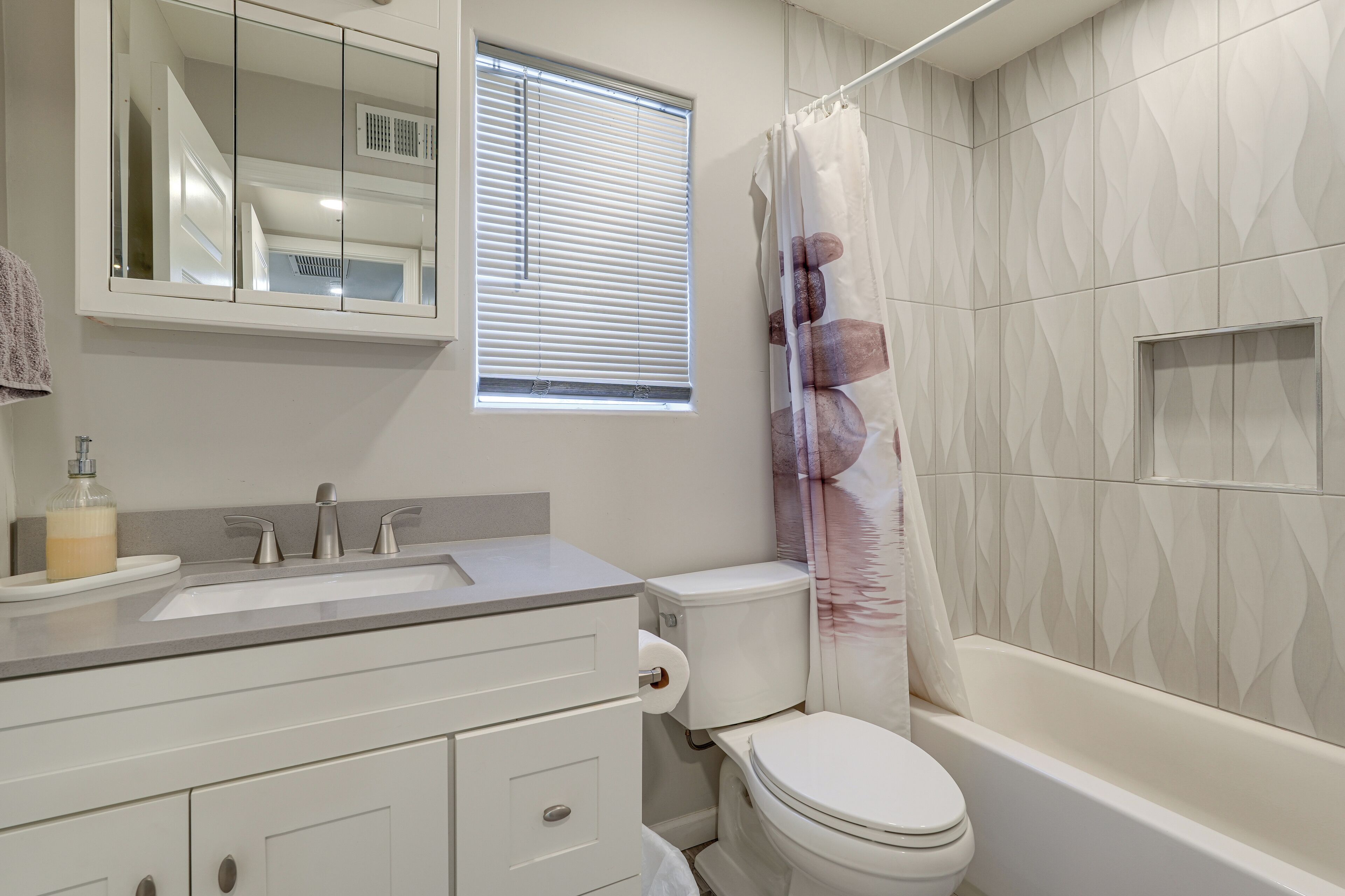 A bathroom with a sink, toilet, and bathtub.