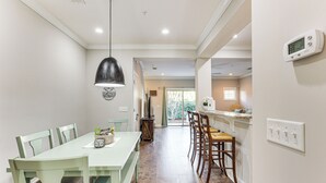 A dining area with a long table, chairs, and a hanging light fixture. - 3 Mi to Pier Village: Dog-friendly St Simons Home! (St. Simons Island)