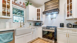 A modern kitchen with white cabinets, a stainless steel oven, a microwave, and a coffee maker. - Artists Retreat w/ Deck! 5 Mi to Dtwn Durham (Durham)
