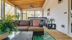 A covered porch with a brown leather sofa, a ceiling fan, and a small table with a plant. - Artists Retreat w/ Deck! 5 Mi to Dtwn Durham (Durham)