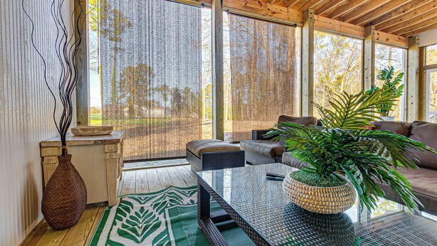A spacious room with a large window, a sofa, a table, and a potted plant. - Artists Retreat w/ Deck! 5 Mi to Dtwn Durham (Durham)