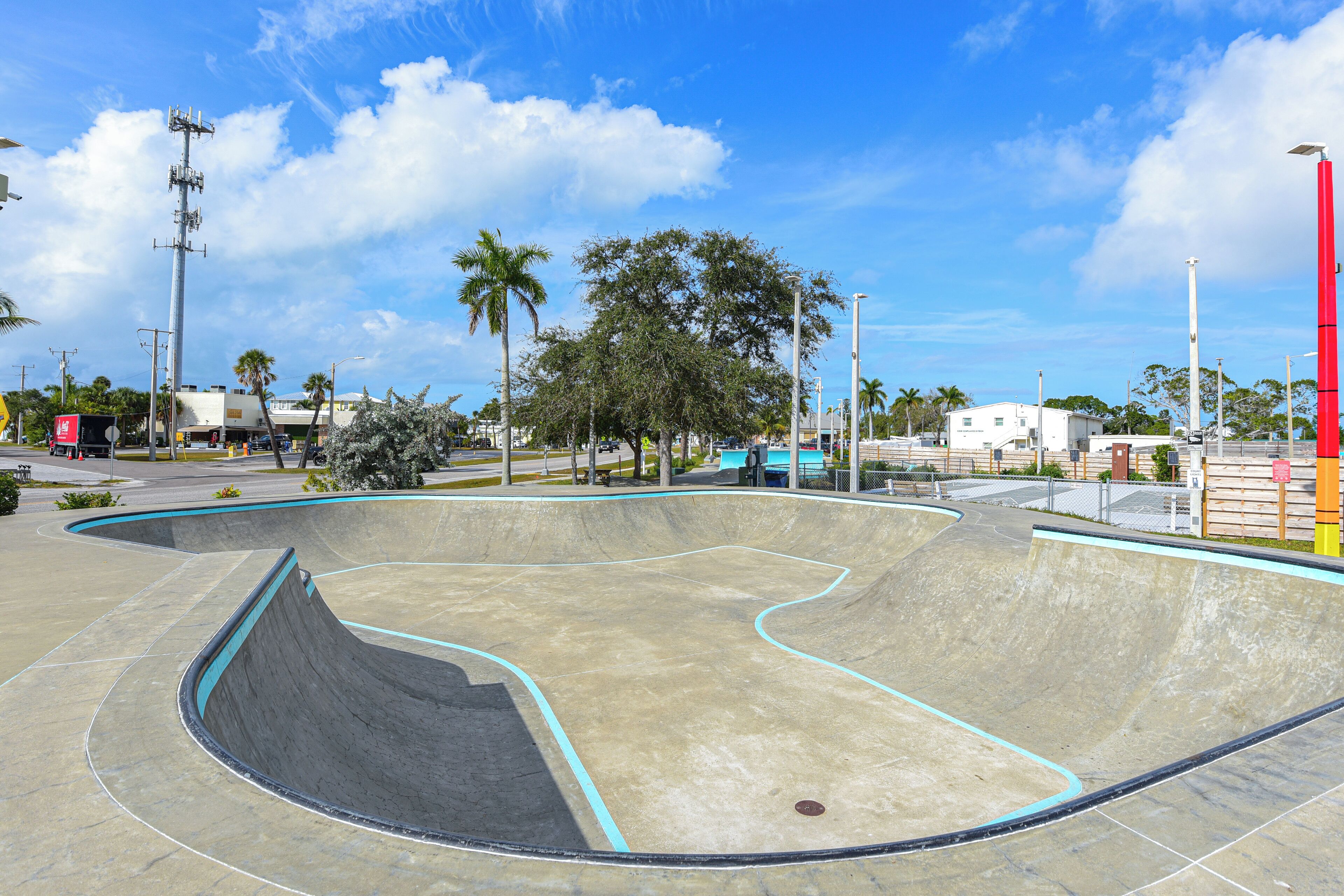 Ein Skatepark mit einer großen Halfpipe und umliegenden Bäumen.