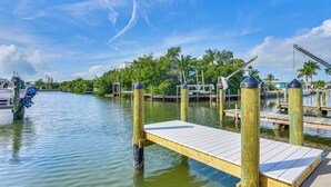 A wooden dock extending into calm water with a clear sky above. - Near Beaches: Waterfront Gem in Anna Maria Island! (Holmes Beach)
