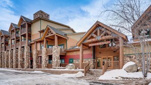 A lodge with a stone facade, wooden balconies, and a sign reading "Hidden River Lodge." - Walk to Ski Lift & Hot Tubs! Mtn-view Keystone Gem (Keystone)