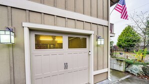 A garage with a white door, two windows, and two wall-mounted lights. - Near Ferry, Shops & Eats! Anacortes Townhome (Anacortes)