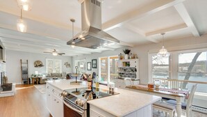 Een ruime keuken met een groot schiereiland, witte kasten en uitzicht op een rivier.