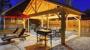 An outdoor covered patio with seating and a red umbrella. - Gather, Play & Unwind! Modern Locust Grove Home (Locust Grove)