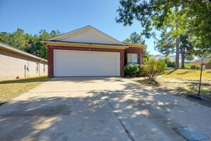 A single-story house with a garage, a brick facade, and a clear driveway. - Game Day Getaway, Ole Miss! Cozy Escape in Oxford (Oxford)