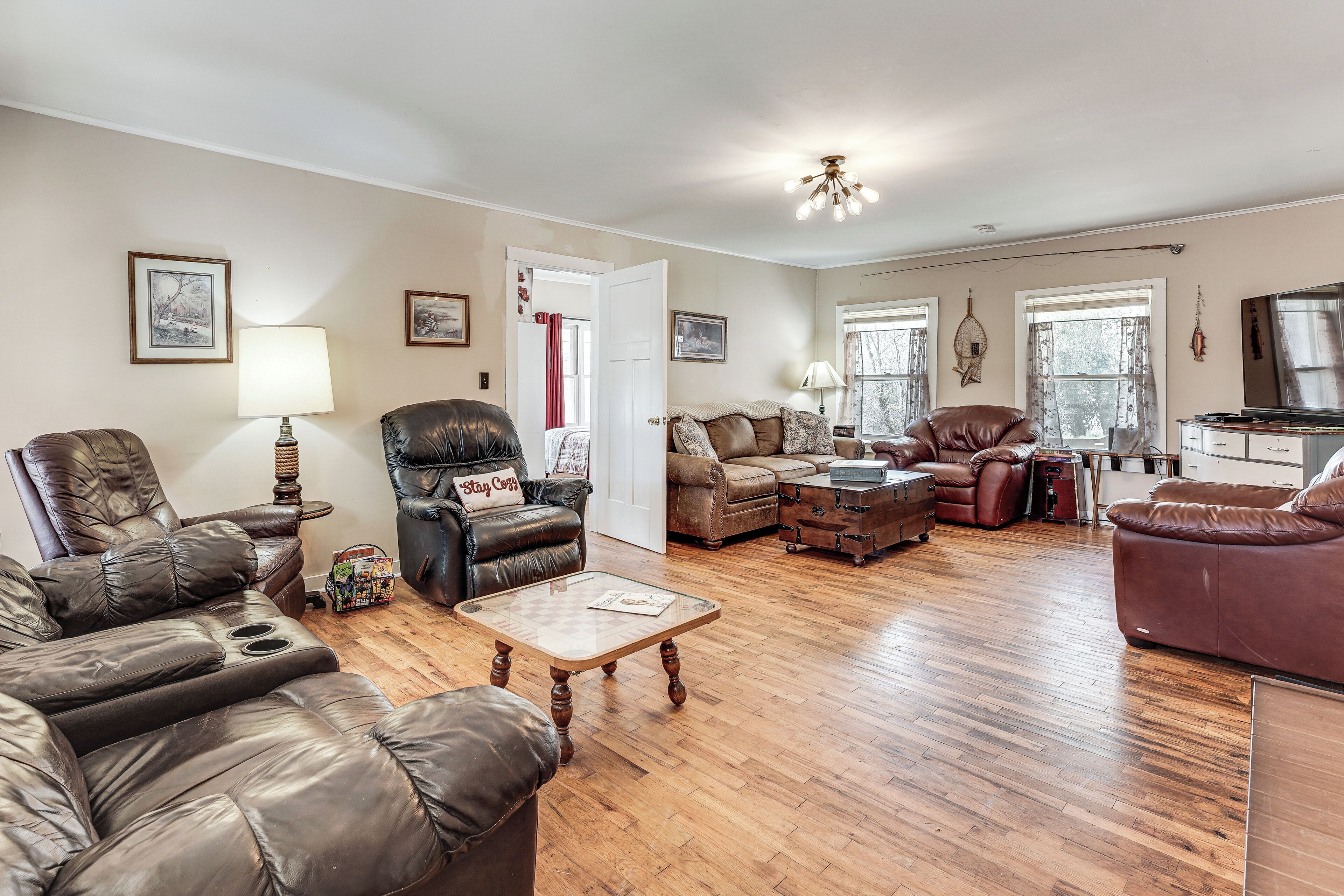 A spacious living room with leather sofas, a wooden coffee table, and a fireplace.