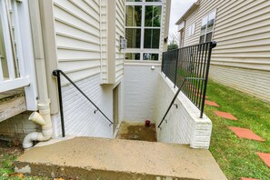 A concrete staircase leading to a white door, surrounded by a black metal railing and a small red bucket on the ground. - Clarksburg Getaway Near DC + Baltimore Sights! (Clarksburg)