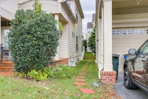 A residential driveway with a pathway leading to a garage, surrounded by houses and a large bush. - Clarksburg Getaway Near DC + Baltimore Sights! (Clarksburg)