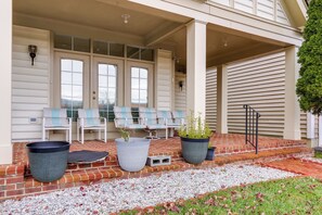 A covered porch with a brick floor, two large planters, and a set of chairs. - Clarksburg Getaway Near DC + Baltimore Sights! (Clarksburg)