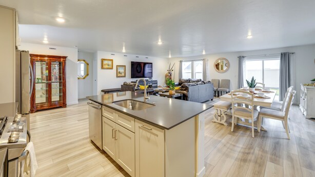 A modern kitchen with a central island, built-in appliances, and a dining area with a large table and chairs. - Newly Built Home w/ Yard, 4 Mi to Dtwn Caldwell! (Caldwell)