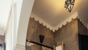 A bathroom with a large mirror, a sink with two faucets, a towel rack, and a woven basket. - Hotel with 5 bedrooms and AC in charming Marrakesh 
your cozy stay book it now (Marrakesh)