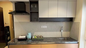 Een moderne keuken met een zwart aanrecht, een roestvrijstalen spoelbak en witte kastjes.