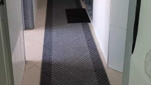 A narrow hallway with a patterned rug, a blue door, and a white wall. - Clean & Cozy Room in Aïn Chock, Casa Nearshore (Casablanca)
