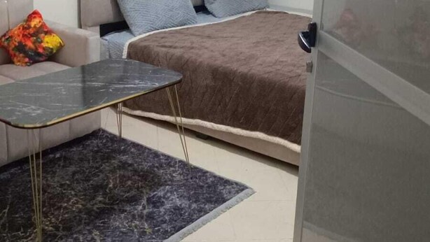 A bedroom with a bed, a sofa, a small table, and a rug. - Clean & Cozy Room in Aïn Chock, Casa Nearshore (Casablanca)