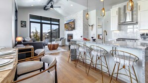 Una cocina moderna con una isla grande, taburetes de bar y una chimenea.