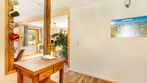 Ein rustikales Interieur mit Tisch, Stühlen, einer Pflanze und einem Wandbild.