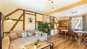 Ein Wohnzimmer mit einer Couch, einem Couchtisch und einem Essbereich mit Stühlen und einem Tisch.