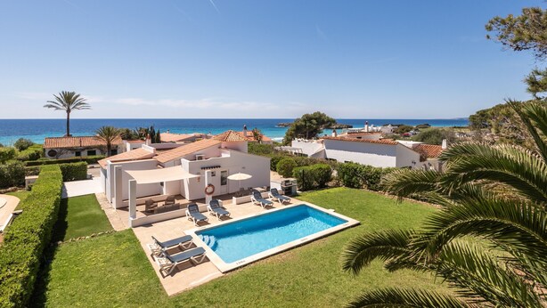 A poolside view of a resort with a clear blue sky, a swimming pool, and a view of the sea. - Villa Marina by Escape Home (Santo Tomas)