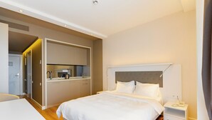 A modern hotel room with a large bed, a small desk, a kitchenette, and a bathroom. - Studio by Alliance (Batumi)