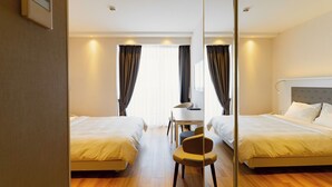 A hotel room with two beds, a desk, and a chair. - Studio by Alliance (Batumi)
