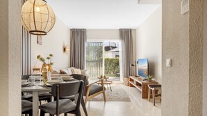 Ein modernes Wohnzimmer mit Essbereich, einem großen Fenster und Blick ins Freie.