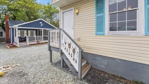 Una casa con veranda coperta, una porta d'ingresso e una cassetta postale.