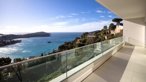 Un balcon offrant une vue dégagée sur la mer et sur une île lointaine.