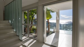 Un intérieur moderne avec un escalier menant à un balcon offrant une vue sur la ville.