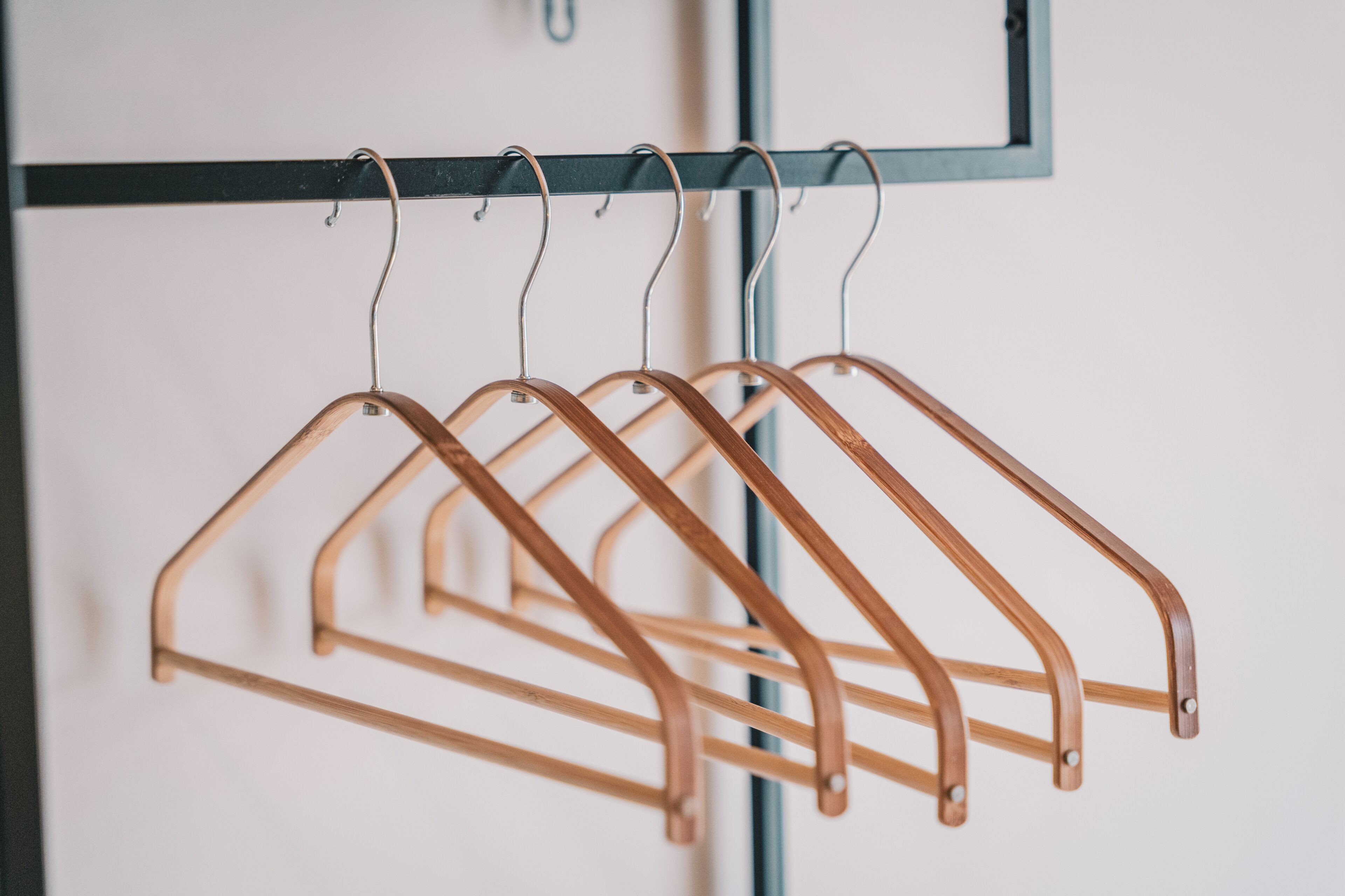 A set of wooden hangers on a metal rack.