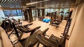 A gym with treadmills, weight machines, and exercise balls.
