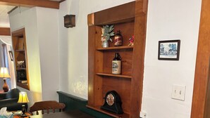 A cozy room with a wooden table, chairs, a small cabinet, and a shelf with various items. - The Minor House - A Cozy Stay in Shullsburg WI (Shullsburg)