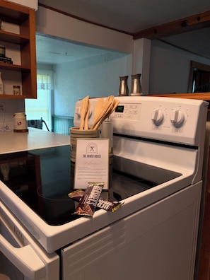A kitchen with a stove, a sign reading 'The Miner House,' and a bag of chips on the counter.