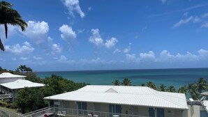 A beachfront hotel with multiple balconies, air conditioning units, and a view of the ocean. - Studio with pool access and views of the Diamond Rock and Morne Larcher (Le Diamant)