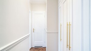 A hallway with a white door, wooden flooring, and white walls. - RentPlanet - Apartament Sobieskiego (Kraków)