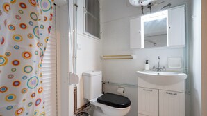 A bathroom with a toilet, sink, and mirror. - Kolonaki Cozy (Athina)
