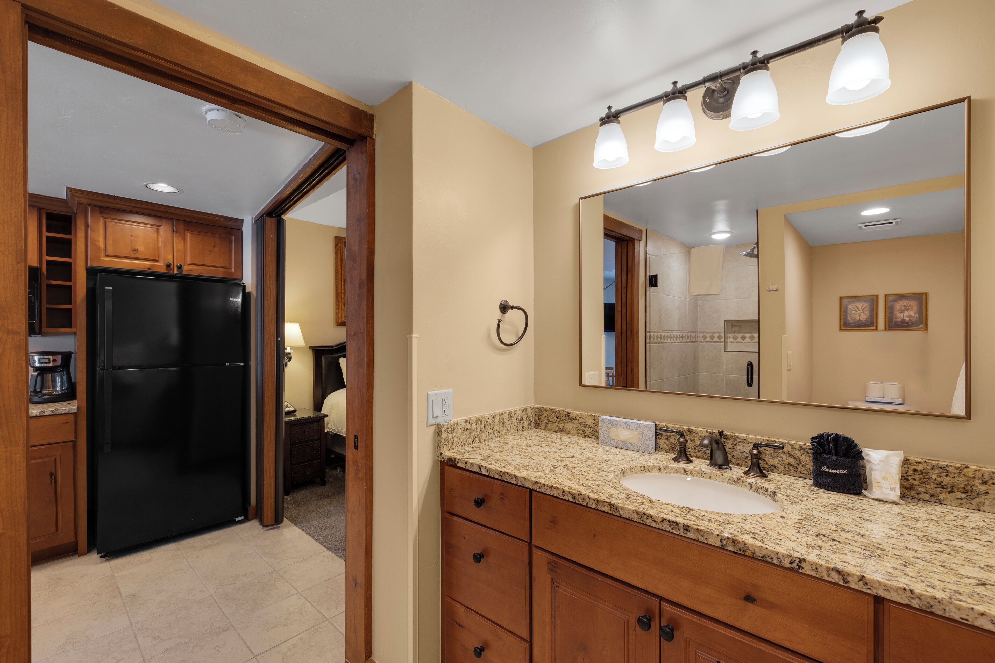 A bathroom with a sink, mirror, and granite countertop.