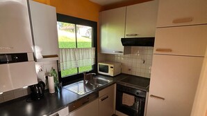 A kitchen with a refrigerator, microwave, sink, and stove. - Holiday Home 'Lechseeidylle' in Elevated Edge Location with 'Königscard' Benefit (Lechbruck am See)