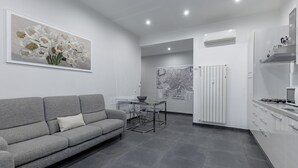 Una cocina moderna con un sofá gris, una mesa de comedor y un mapa en la pared.