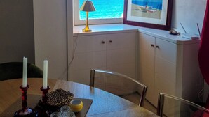 A room with a view of the sea, a framed picture on the wall, a table with candles, and a lamp. - Casa Azzurra (Pizzo)
