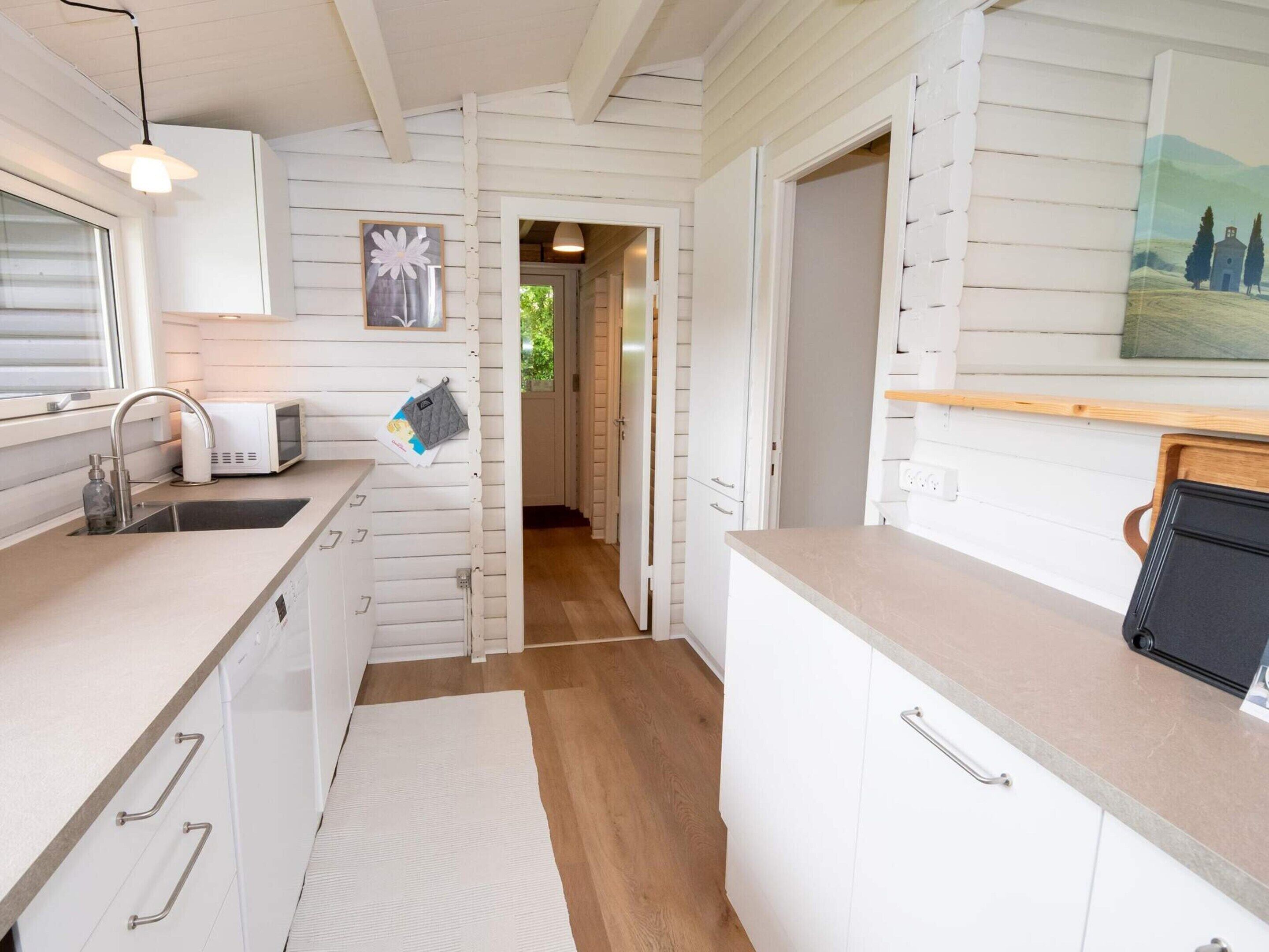A kitchen with white cabinets, a microwave, and a sink.