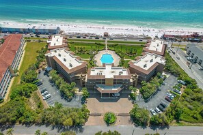 Un hôtel doté d’une cour intérieure, d’une piscine et offrant une vue sur la plage.