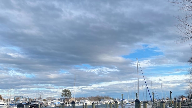 A marina with wooden pilings and boats docked.